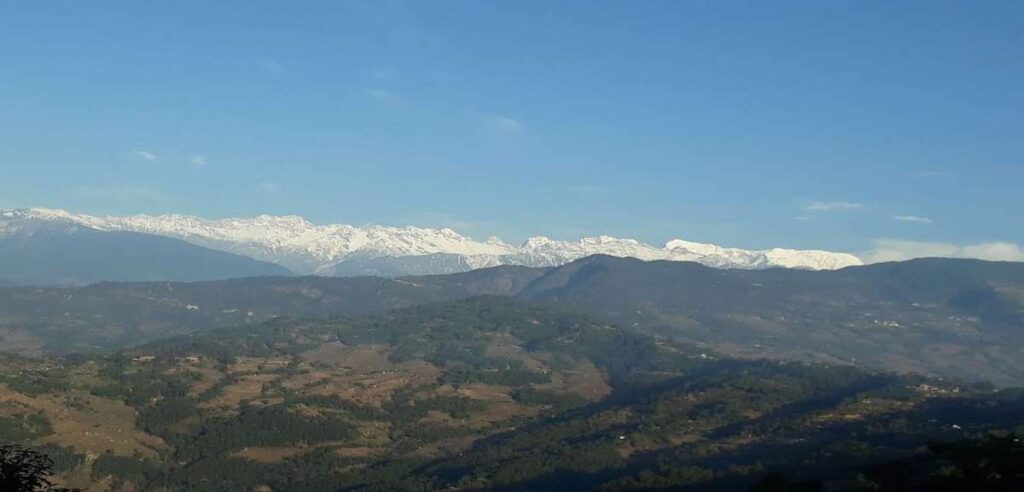 Panoramic view of snow-capped Himalayan peaks seen during a One Day Sightseeing Tour in eastern Nepal.