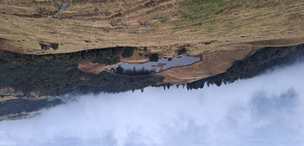 Hanspokhari Lake surrounded by rolling hills along the Mundum Trek route in eastern Nepal