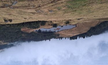 Hanspokhari Lake surrounded by rolling hills along the Mundum Trek route in eastern Nepal