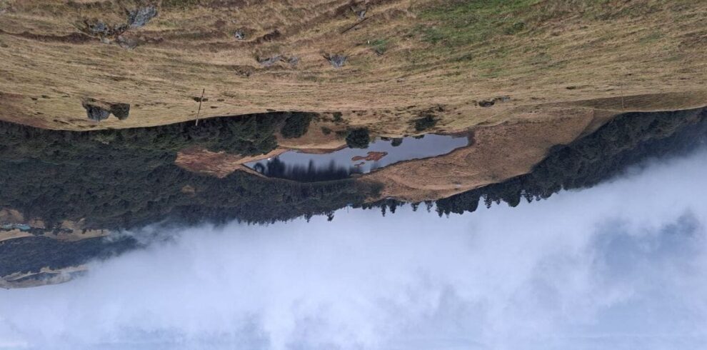 Hanspokhari Lake surrounded by rolling hills along the Mundum Trek route in eastern Nepal
