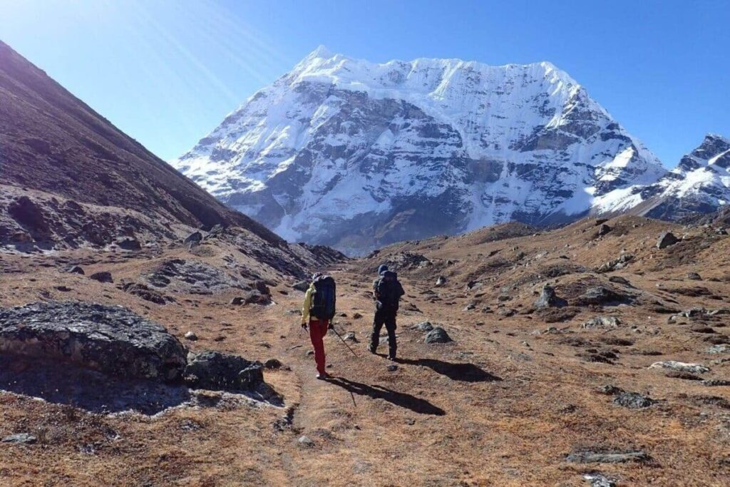 Trekkers walking toward the snow-covered peaks of Mount Makalu during the Makalu Base Camp Trek in eastern Nepal
